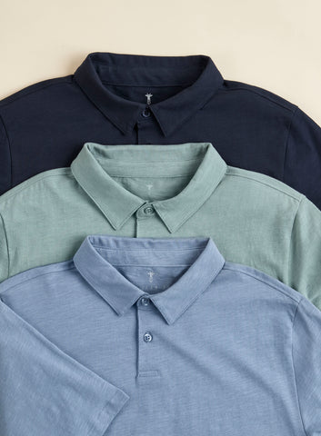 three polo shirts laid out overlapping in various colors