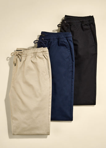 Three pairs of pants stacked on top of each other