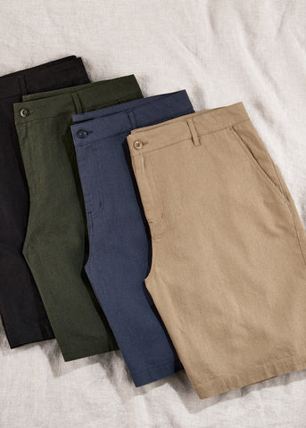 Four pairs of folded chino shorts stacked on top of each other