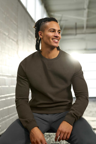 Man seated smiling looking off to the side wearing camo green crewneck sweatshirt for tall men