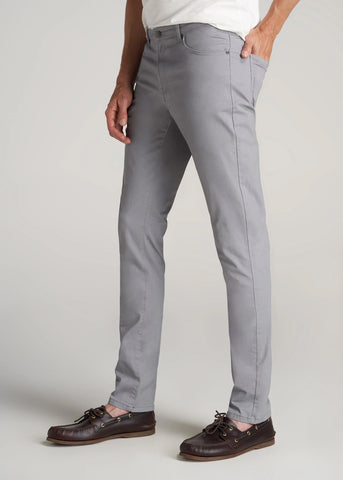Closeup of man wearing 5-pocket style grey pants