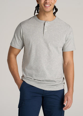 Man with one hand in pocket wearing henley t-shirt in heather grey