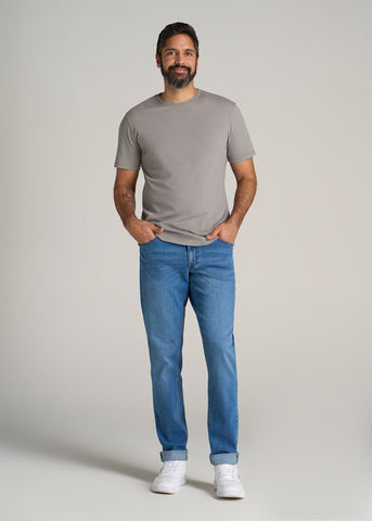 Tall man wearing jeans and crewneck t-shirt in light charcoal color