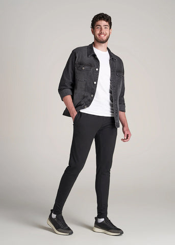 Man wearing tapered athletic joggers with tee and jean jacket