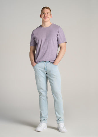 Man wearing light blue jeans and light purple tee