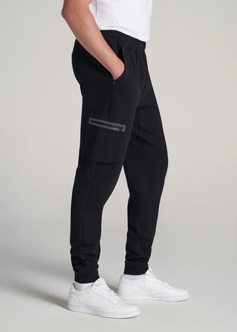 Tall man standing with hand in pocket of utility joggers