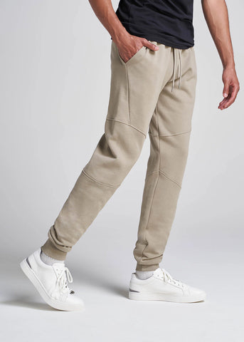 Closeup of man's legs standing with hand in pocket wearing tall joggers